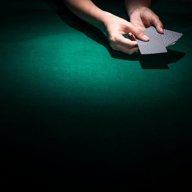 Person hand's holding poker card