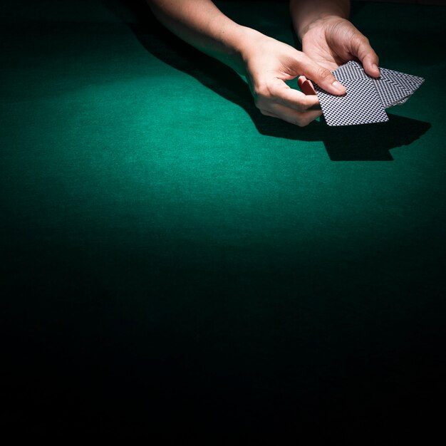 Person hand's holding poker card