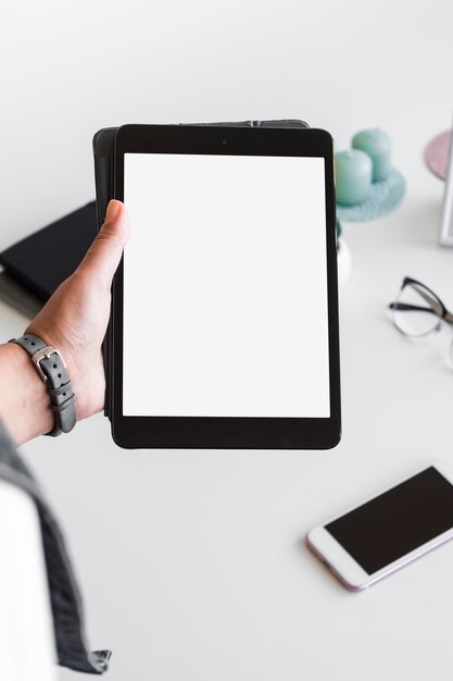 Person hand with tablet near table with equipments