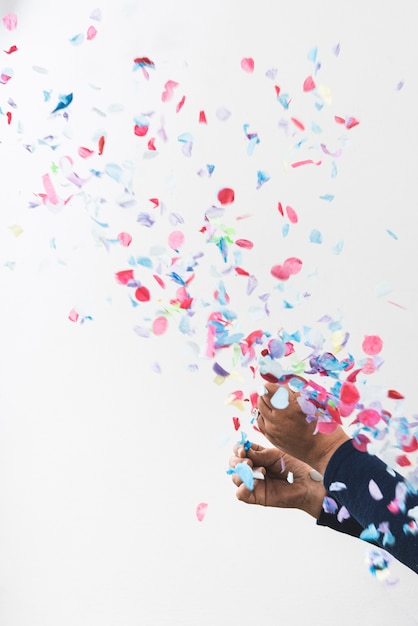 Free photo person hands and colorful confetti