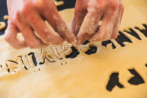 Free photo person hands taking away dough letters