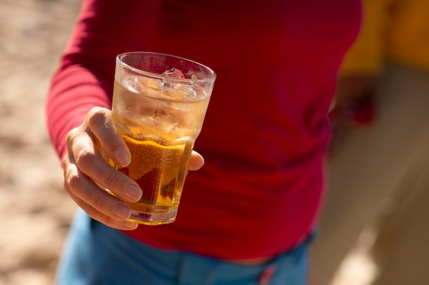 Foto gratuita persona che beve guaranà all'aperto