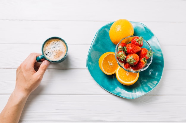 Person having organic fruits and tasty beverage on white textured backdrop