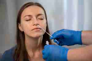 Free photo person helping a woman taking a covid test at home