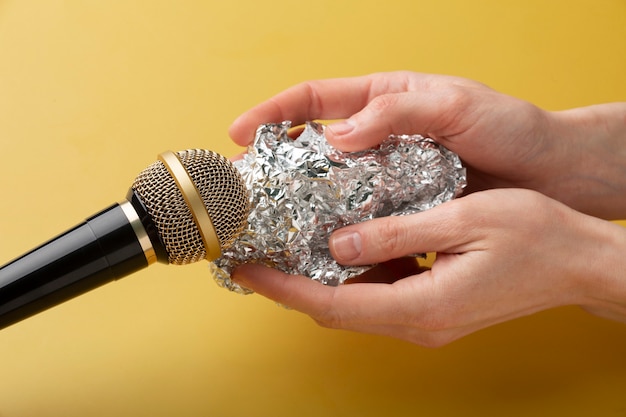 Free photo person holding aluminium foil close to microphone for asmr