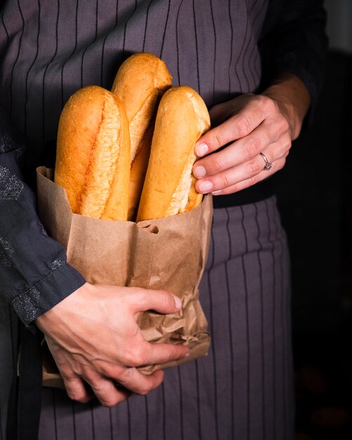Person holding bag with baguettes