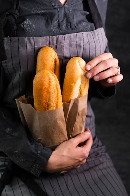 Free photo person holding bag with fresh baguettes