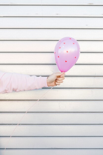 Person holding balloon with ornament hearts 