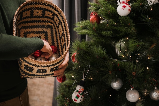 Person holding basket with christmas tree