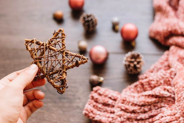 Person holding big wooden star in hand 