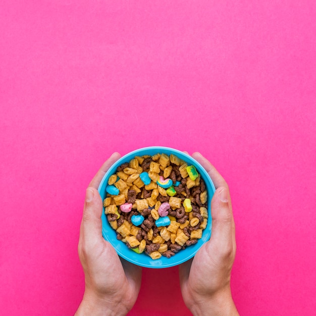 Person holding blue bowl with cereal