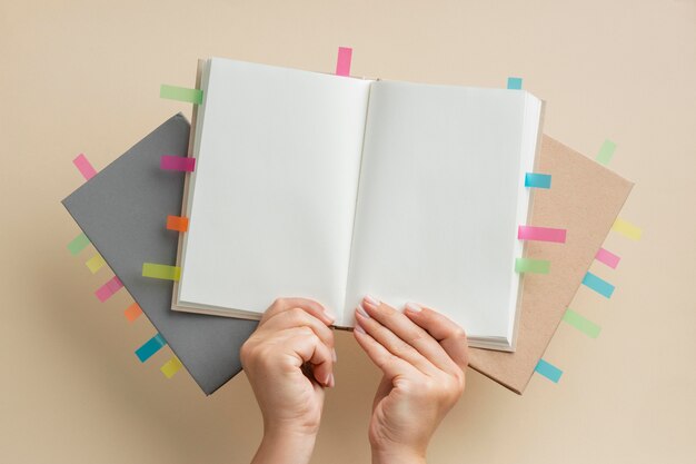 Person holding books with colorful reminders stickers