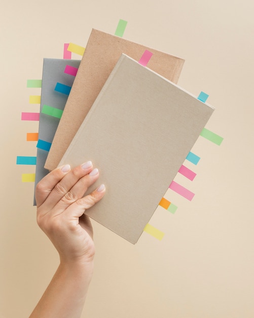 Free photo person holding books with colorful reminders stickers