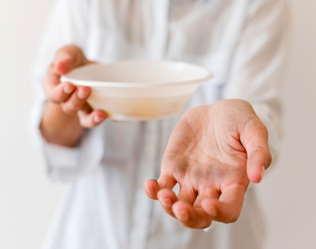 Person holding bowl of soup asking for donation