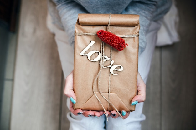 Person holding brown package with word "love"