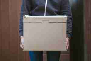 Free photo person holding a cardboard box