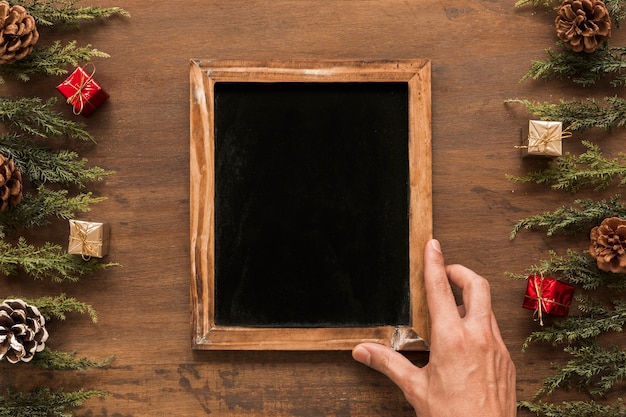 Free photo person holding chalkboard on table