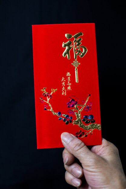 Person holding a Chinese traditional red envelop for the celebration of Chinese New Year