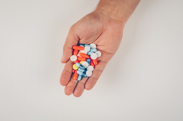 Foto gratuita persona in possesso di pillole colorate