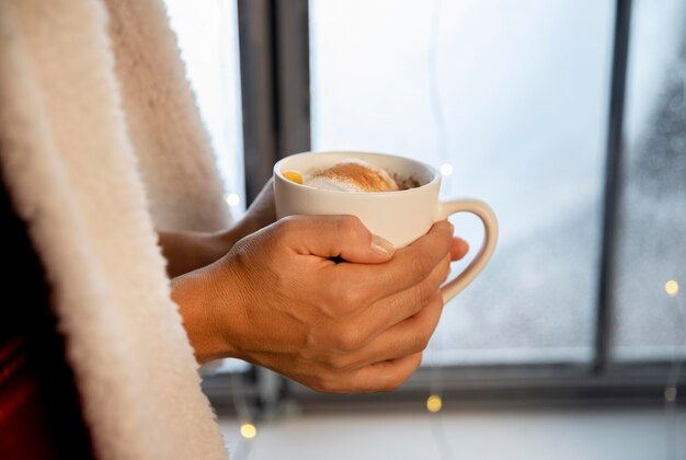 Free photo person holding a cup of hot chocolate