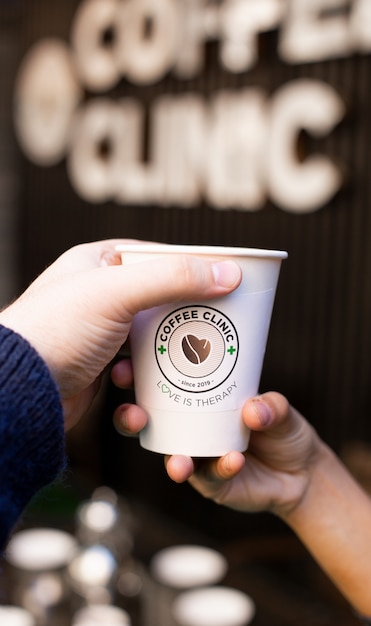 Free photo person holding a disposable cup of coffee