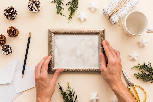 Person holding frame on beige table 