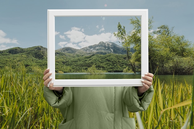 Person holding frame with open nature landscape concept