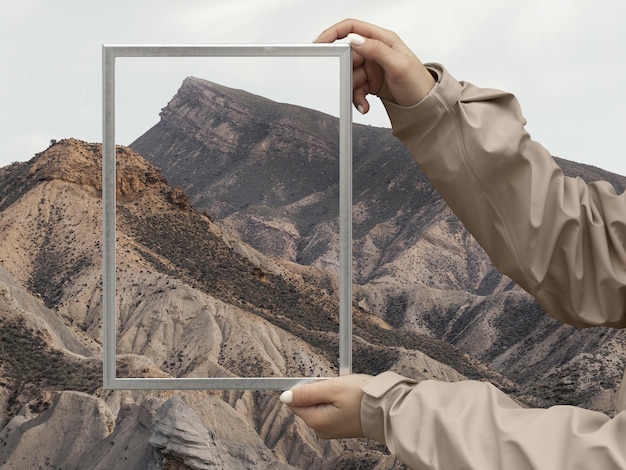 Person holding frame with open nature landscape concept