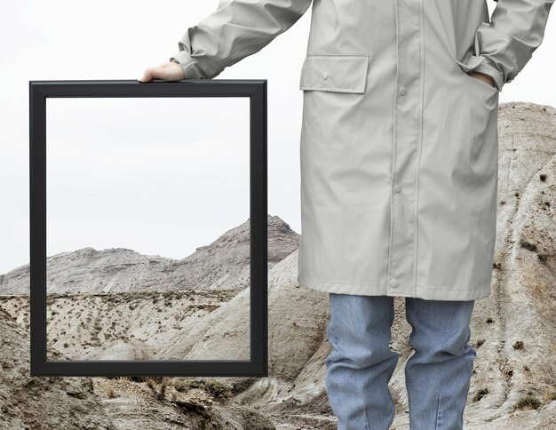 Person holding frame with open nature landscape concept