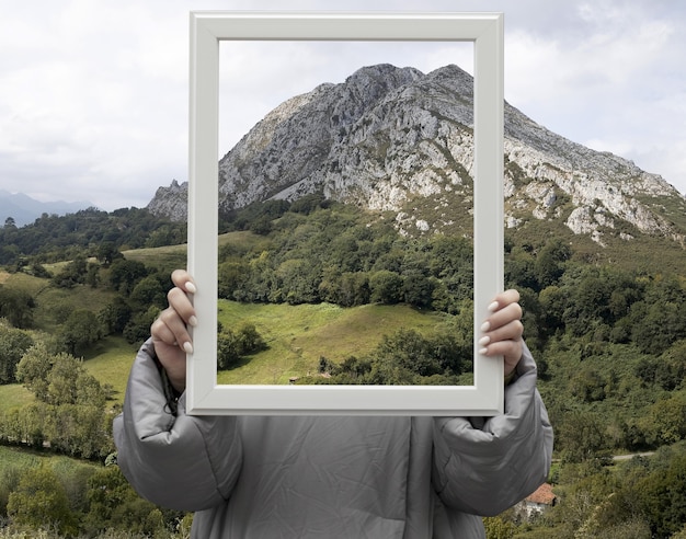 Person holding frame with open nature landscape concept