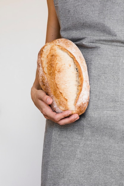 Бесплатное фото Лицо, занимающее свежеиспеченный хлеб