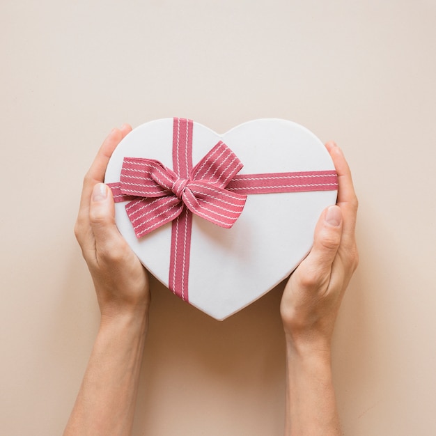 Person holding gift box in heart shape