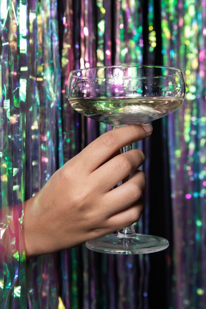 Person holding a glass of champagne front view