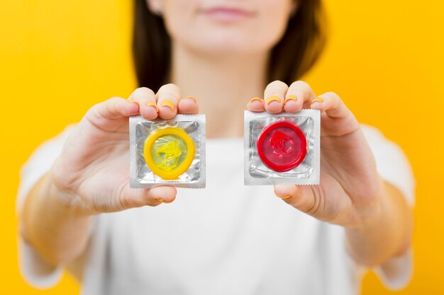 Person holding in hands two condoms