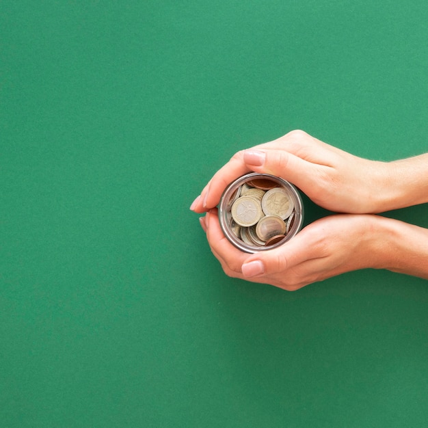 Free photo person holding a jar with coins with copy space