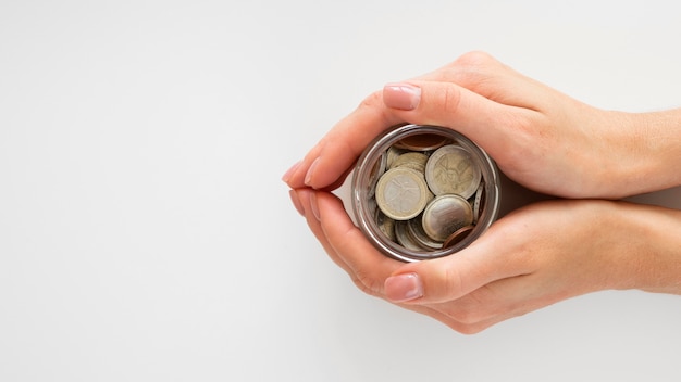 Person holding a jar with coins
