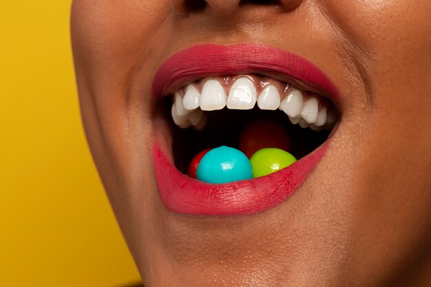 Person holding jelly bean candy in their mouth