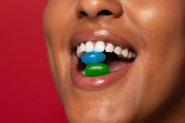 Person holding jelly bean candy in their mouth