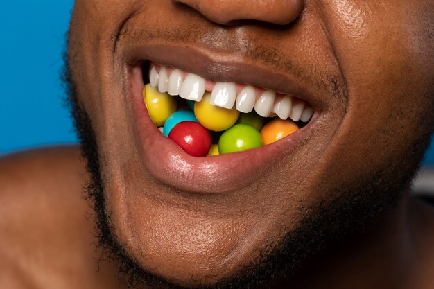 Person holding jelly bean candy in their mouth