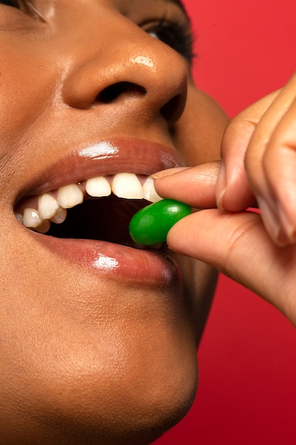 Person holding jelly bean candy in their mouth