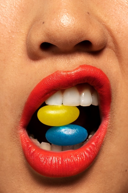 Person holding jelly bean candy in their mouth