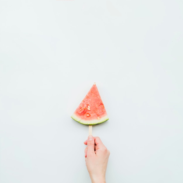 Person holding juicy fresh watermelon popsicle 