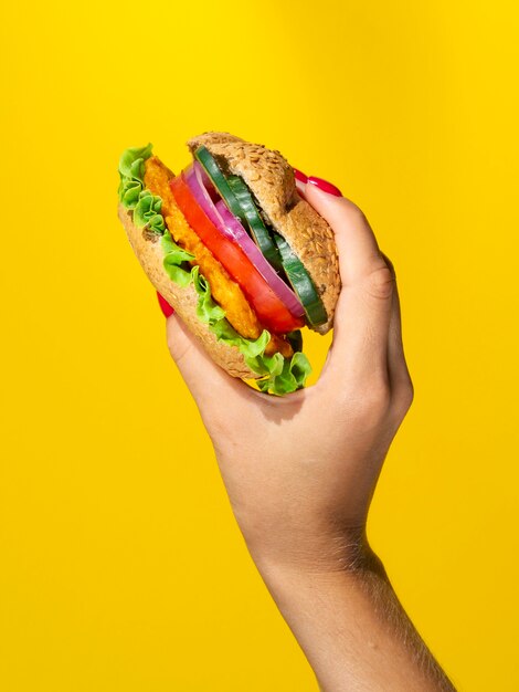 Person holding a juicy veggie burger 