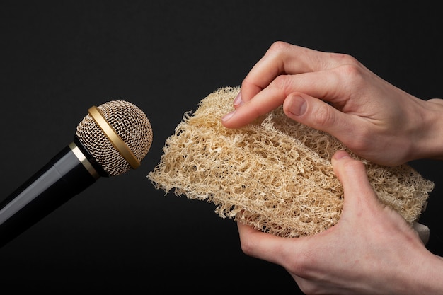 Person holding loofah close to microphone for asmr