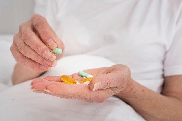 Person holding many colorful pills
