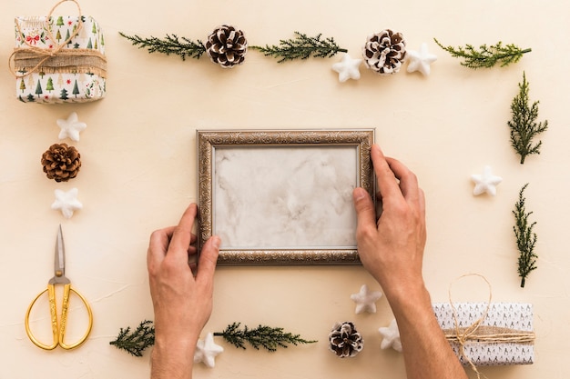 Person holding metallic frame on table 