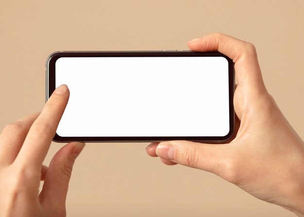 Person holding a mobile phone with white screen