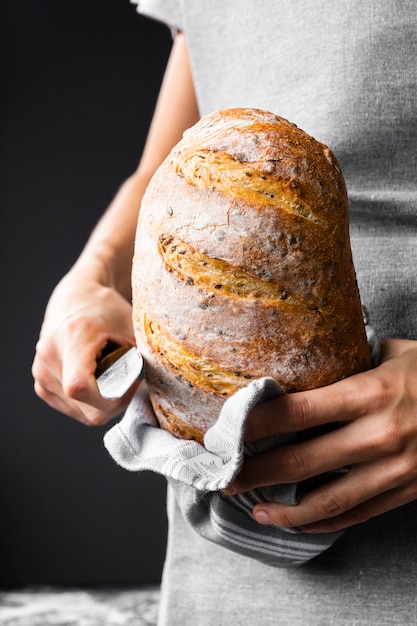 Foto gratuita persona in possesso di pagnotta di pane nutrizionale