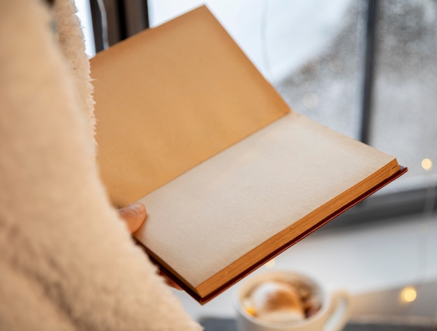 Person holding an opened empty book close-up