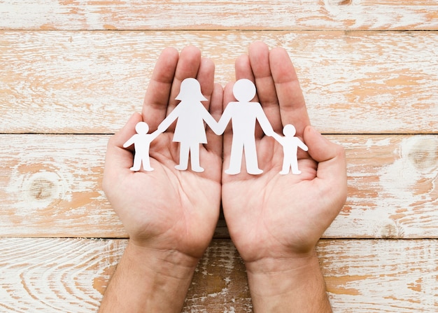 Person holding paper family in hands